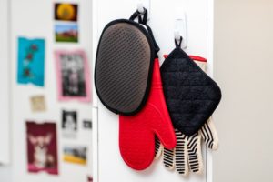 Kitchen pantry organization ideas include hanging oven mitts and utensils on hooks.